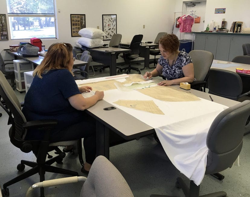 Pam Phelps and Faith Peix work on altering a pattern.